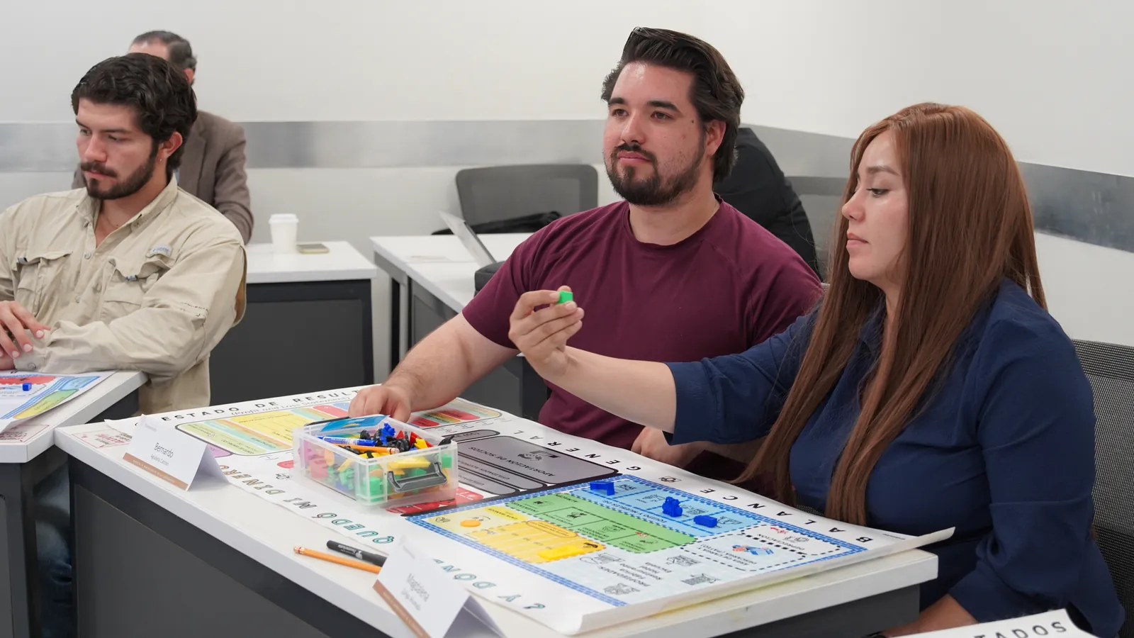 Participantes de posgrado moviendo fichas en el tablero